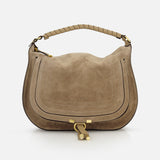 The CHLOÉ Marcie Suede Top Handle Bag features taupe suede, gold-tone hardware, a curved shape, stitched details, matching wrapped leather handles, and a decorative front lock. A plain white background highlights its elegant design.