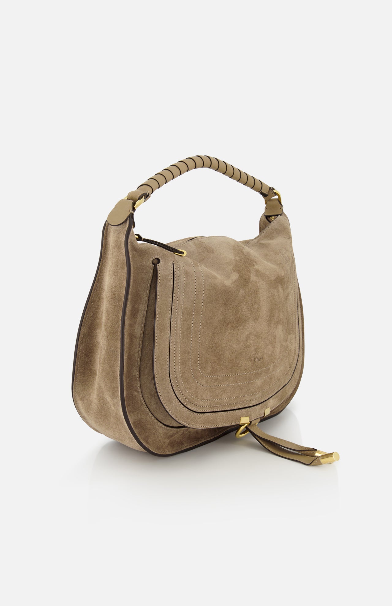 The CHLOÉ Marcie Suede Top Handle Bag, shown in taupe with a curved flap, gold hardware, thick leather handles, visible stitching, and a decorative strap with gold accents, is displayed against a white background.