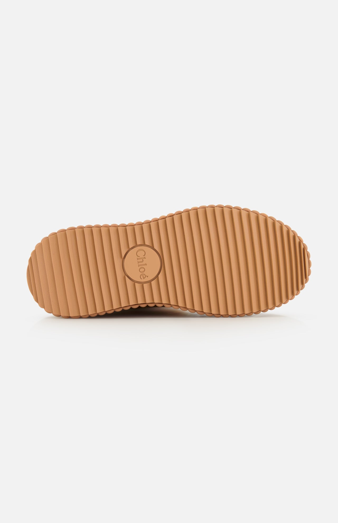 Tan ribbed rubber sole with horizontal grooves, shown from below. Perfect for Nama Suede and Shearling Boots, featuring CHLOÉ embossed in the center circle on a plain white background.
