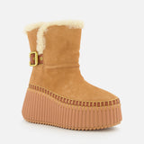 CHLOÉ Nama Suede and Shearling Boots in tan feature a thick ridged platform, yellow stitching, side buckle, and visible cozy shearling at the top. Displayed on a plain white background.