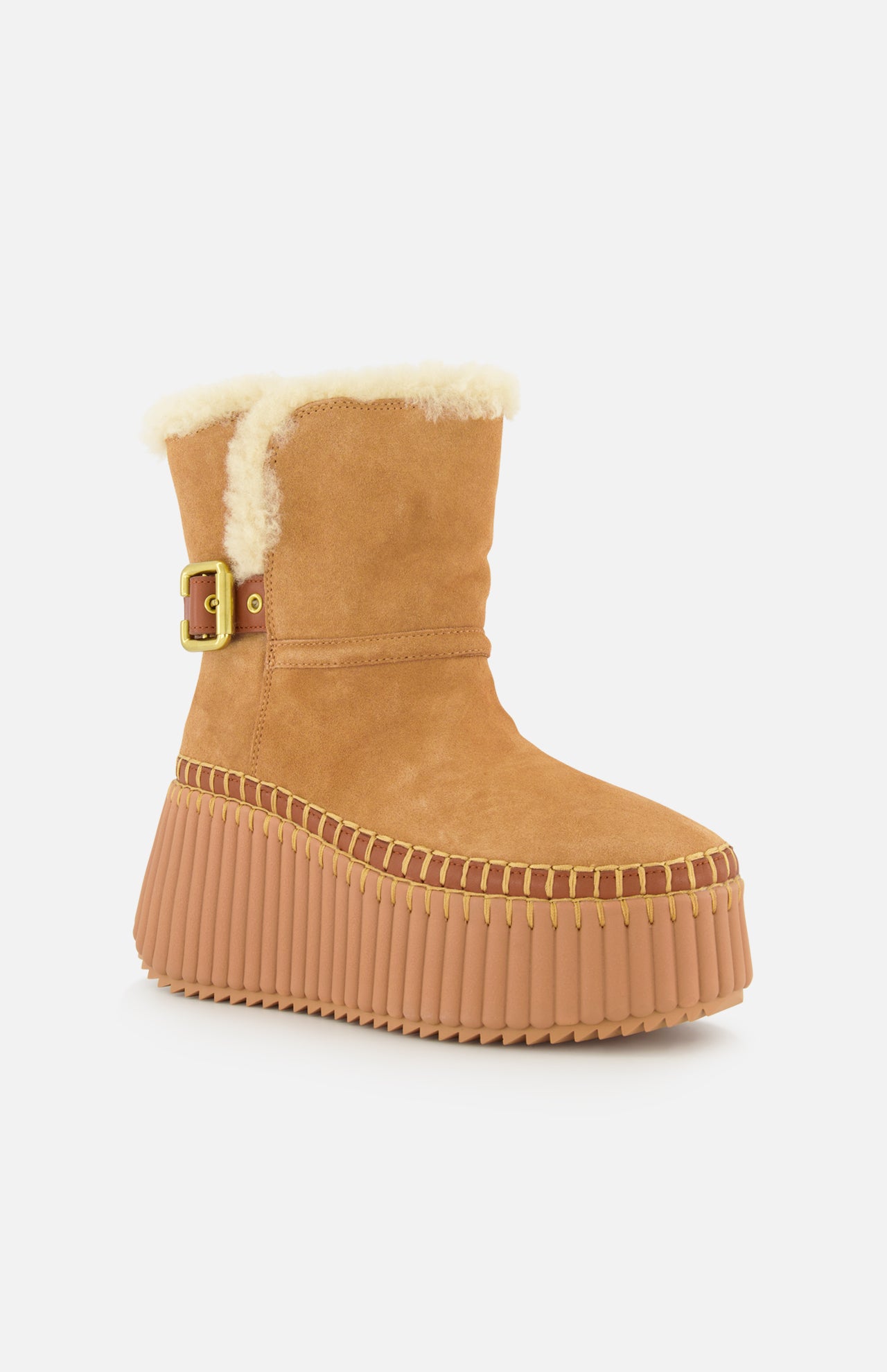 CHLOÉ Nama Suede and Shearling Boots in tan feature a thick ridged platform, yellow stitching, side buckle, and visible cozy shearling at the top. Displayed on a plain white background.