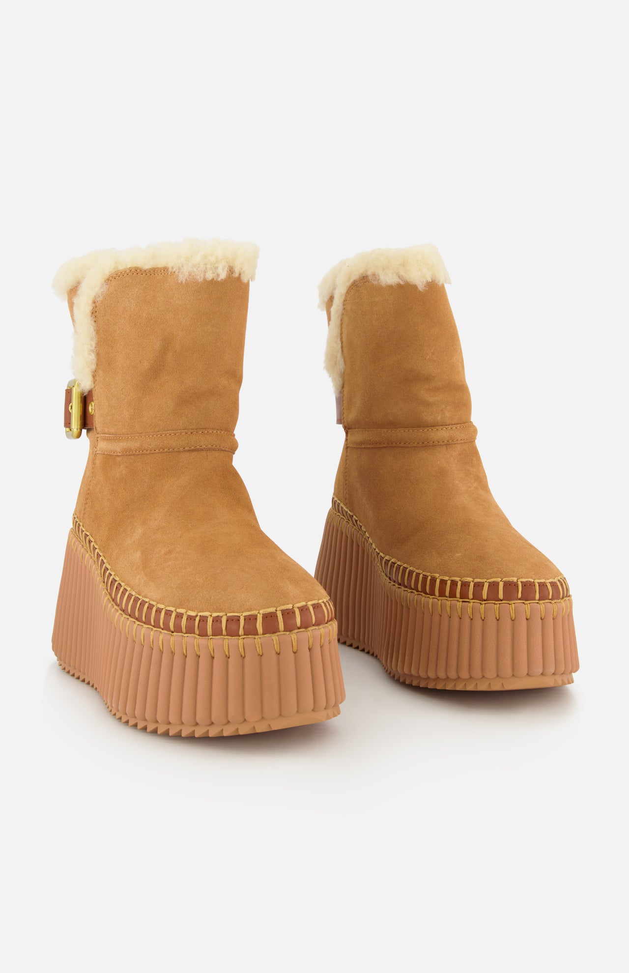 Nama Suede and Shearling Boots by CHLOÉ in tan suede with shearling lining, chunky rubber platform soles, stitched details, and a side buckle, shown on a white background.