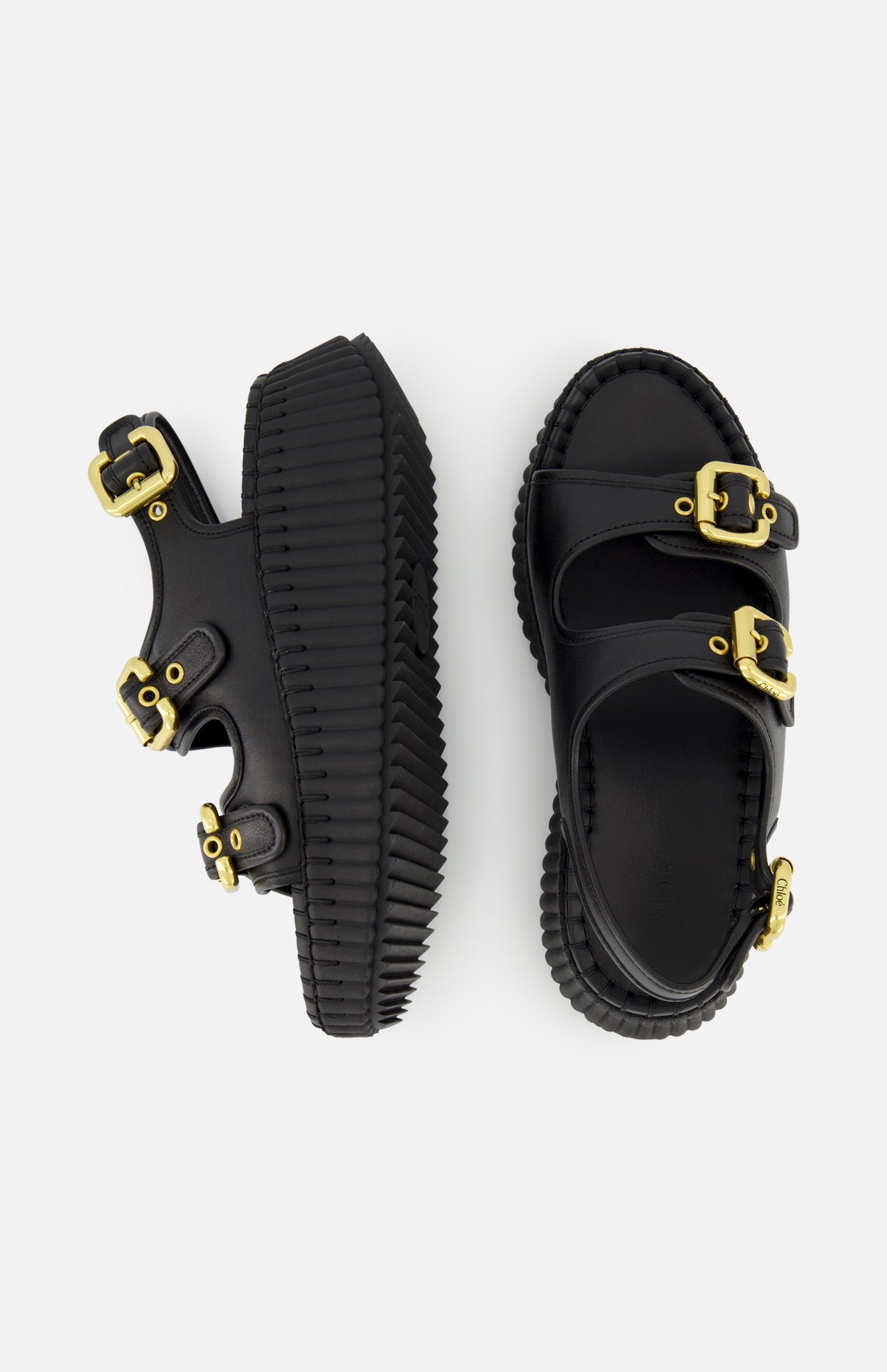 The CHLOÉ Nama Buckle Wedge Sandals feature black leather, thick ridged platform soles, and three wide straps with large gold buckles. One sandal is shown from the side and one from above against a plain white background.