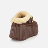 The Nama Suede Slippers by CHLOÉ feature brown suede uppers, a thick ribbed wedge sole, plush cream shearling lining, and a gold buckle detail. Photographed against a plain white background, these chic platform slip-ons effortlessly combine style and comfort.
