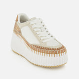 The CHLOÉ Nama Wedge Sneaker features white leather, woven tan accents, beige trim, white laces, and a chunky ridged sole—perfect statement footwear showcased on a plain white background.