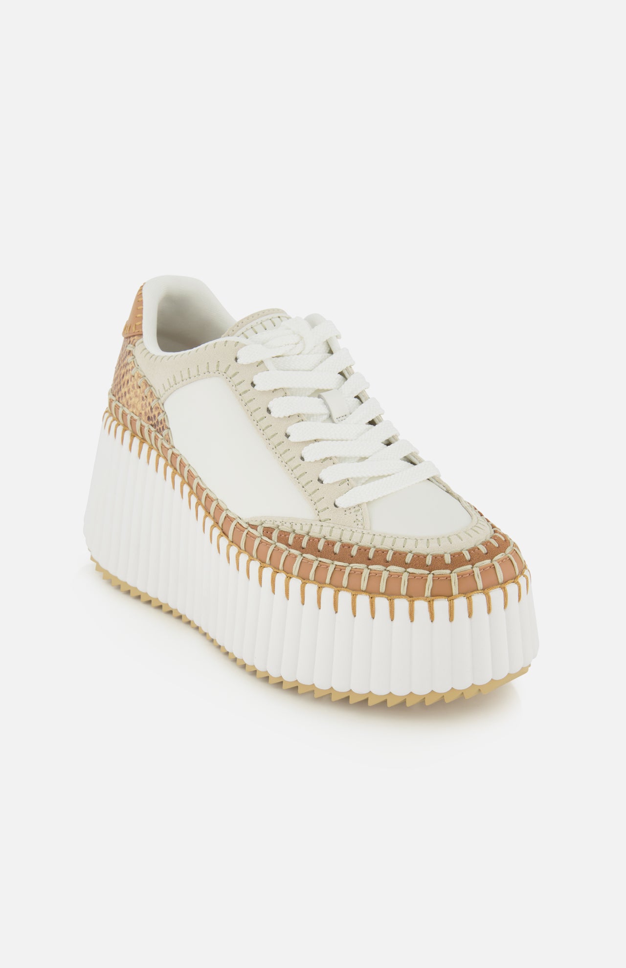 The CHLOÉ Nama Wedge Sneaker features white leather, woven tan accents, beige trim, white laces, and a chunky ridged sole—perfect statement footwear showcased on a plain white background.