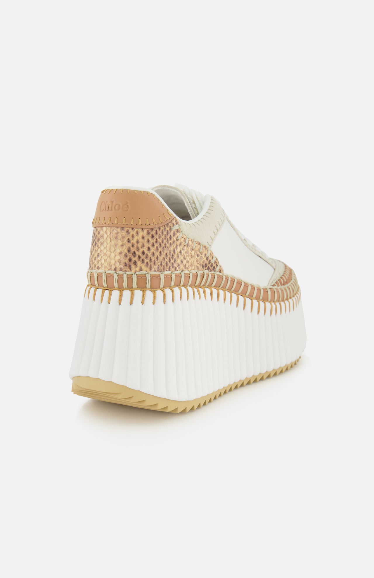 The CHLOÉ Nama Wedge Sneaker features a chic leather design with a thick ribbed white platform sole, beige and tan accents, and visible stitching, showcased from the back left against a white background.