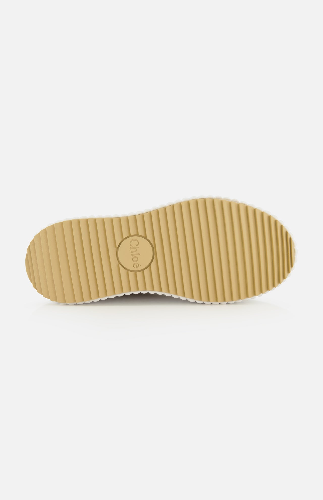 The image displays the bottom view of a beige Nama Wedge Sneaker sole with horizontal grooves and the CHLOÉ logo embossed in a central circle, highlighting its distinctive design against a plain white background.