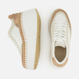 Two Nama Wedge Sneakers by CHLOÉ are shown from top and side views, featuring cream and tan leather with thick ribbed white soles, tan accents, and textured brown details at the heel and toe—perfect statement sneakers.