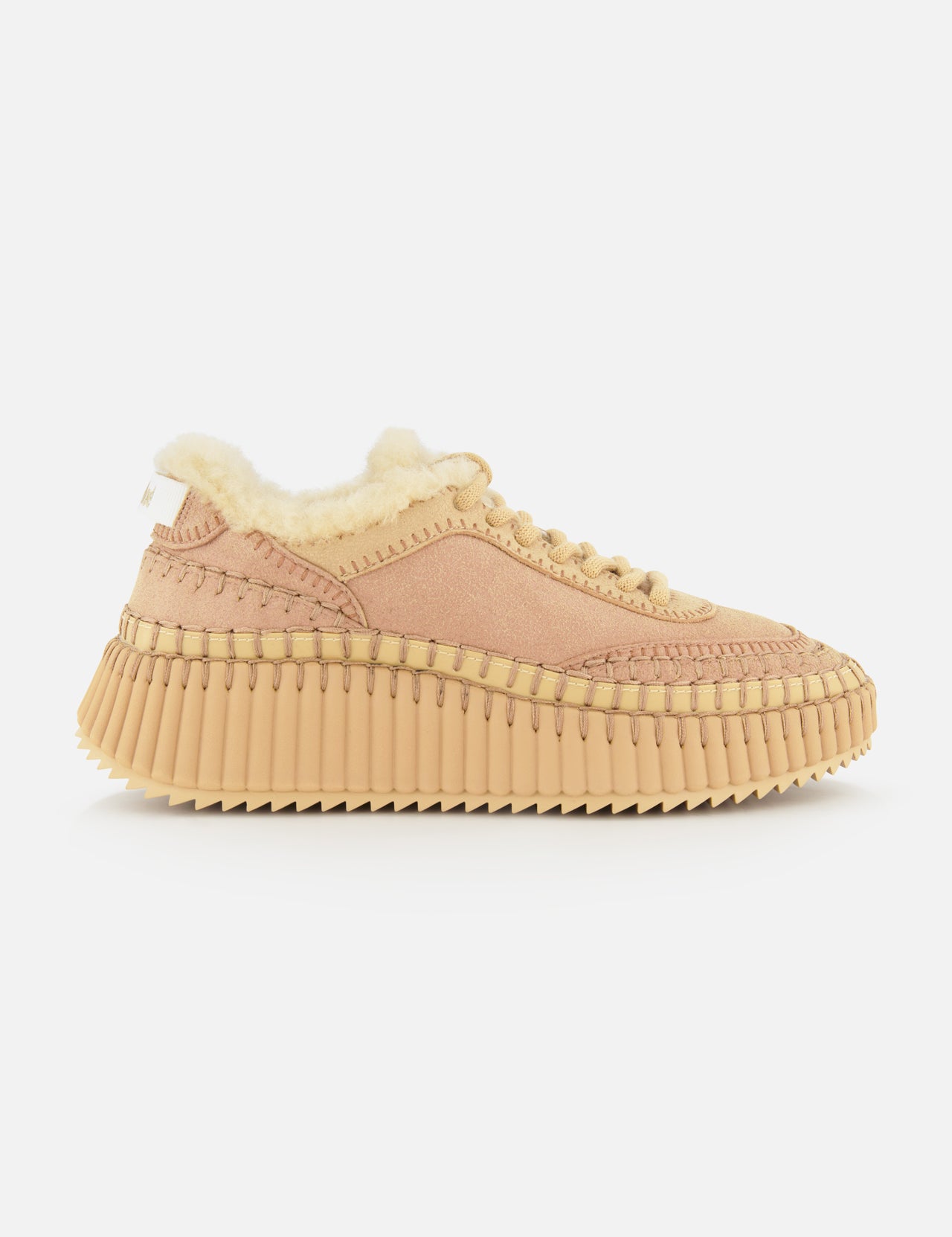 The Nama Shearling Lining Sneakers by CHLOÉ feature a light pink upper with subtle tan stitching, a thick, ridged recycled sole in tan, and a plush cream shearling lining. Presented in profile against a plain white background.