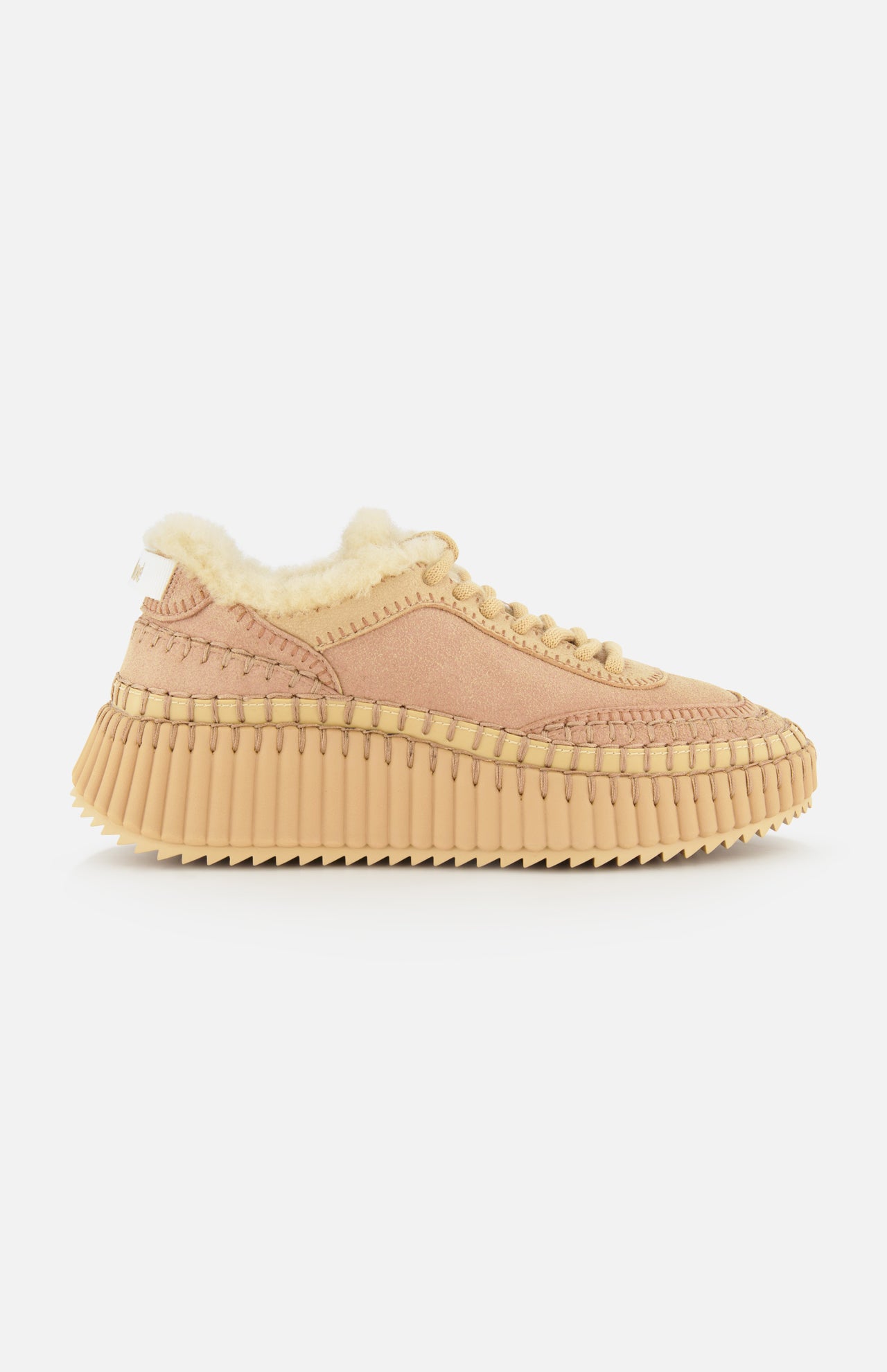 The Nama Shearling Lining Sneakers by CHLOÉ feature a light pink upper with subtle tan stitching, a thick, ridged recycled sole in tan, and a plush cream shearling lining. Presented in profile against a plain white background.