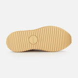 Beige sole of the Nama Shearling Lining Sneakers by CHLOÉ, featuring evenly spaced horizontal ridges and a central circular “Chloé” logo, crafted from recycled materials. Displayed against a plain white background.