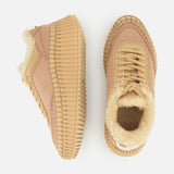 Two Nama Shearling Lining Sneakers by CHLOÉ, featuring thick ribbed recycled soles and light beige shearling lining, are displayed on a white background—one shoe viewed from the side, the other from above.