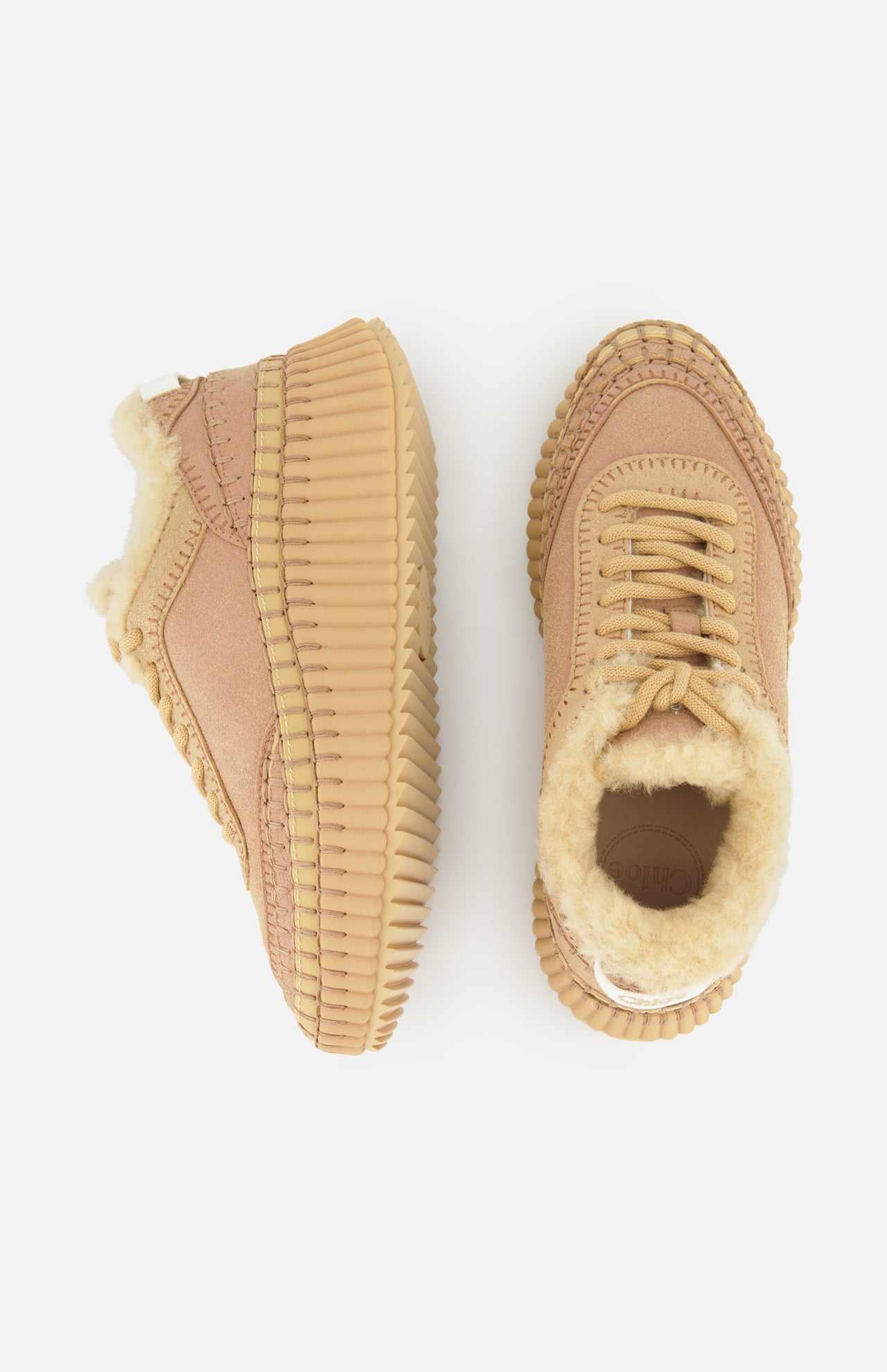 Two Nama Shearling Lining Sneakers by CHLOÉ, featuring thick ribbed recycled soles and light beige shearling lining, are displayed on a white background—one shoe viewed from the side, the other from above.