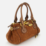 The CHLOÉ Suede Paddington Shoulder Bag features brown suede and leather, gold hardware, decorative buckles, an oversized padlock, double handles, and a structured design.