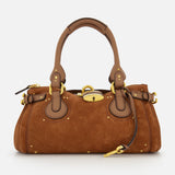 The CHLOÉ Suede Paddington Shoulder Bag features tan brown suede, gold hardware, leather handles and trim, side buckles, an oversized padlock clasp, a structured rounded silhouette, and decorative stitching.
