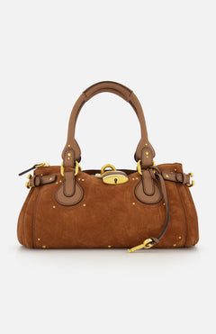 The CHLOÉ Suede Paddington Shoulder Bag features tan brown suede, gold hardware, leather handles and trim, side buckles, an oversized padlock clasp, a structured rounded silhouette, and decorative stitching.