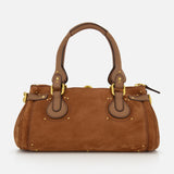 The CHLOÉ Suede Paddington Shoulder Bag features brown suede, double handles, gold-tone hardware, an oversized padlock, and leather trim, shown against a plain white background.