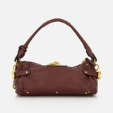 A CHLOÉ Paddington Shoulder Bag with Removable Strap, crafted from dark brown leather with gold hardware, a short handle, and decorative rivets, featuring an oversized padlock and displayed against a white background.