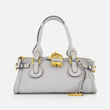 The CHLOÉ Paddington Shoulder Bag is a light gray leather handbag featuring two handles, gold hardware, and a prominent oversized padlock detail on the front, reminiscent of the iconic Paddington style.