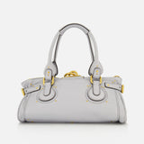 A CHLOÉ Paddington Shoulder Bag in light gray leather, featuring gold hardware, double handles, decorative buckles, subtle stitching details, and an oversized padlock accent, displayed against a plain white background.