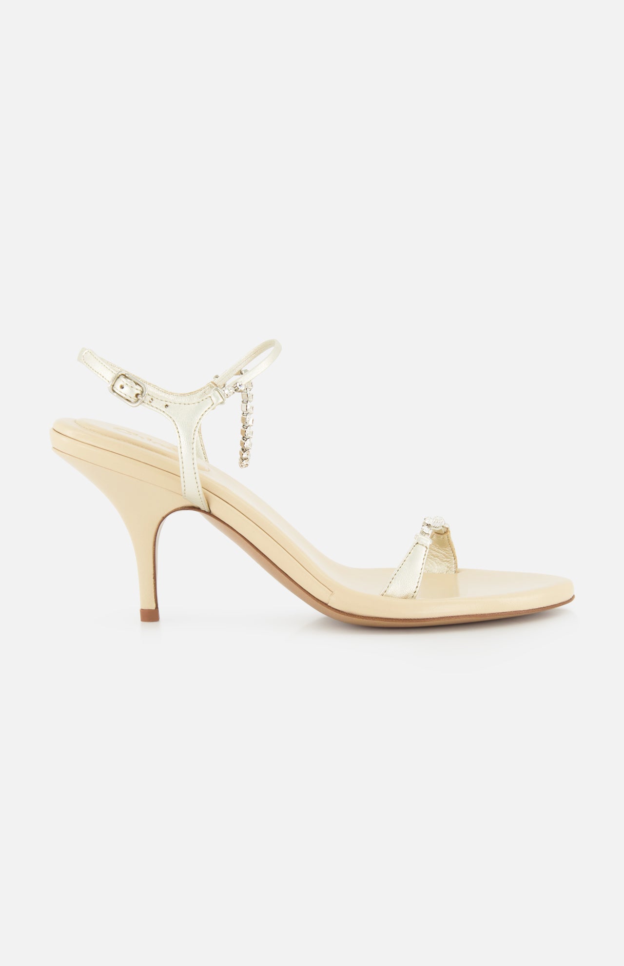 The Zia Crystal Chain Heels by CHLOÉ are elegant beige heeled sandals featuring a slim ankle strap with a delicate buckle and an open toe, crafted in the refined style of classic Italian designer shoes and displayed in profile against a plain white background.