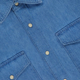 Close-up of the Army Long Sleeve Shirt by CLOSED, a regular fit blue denim shirt with chest patch pockets, silver snap buttons, and a collar. The inner collar features a white label with CLOSED in black text.