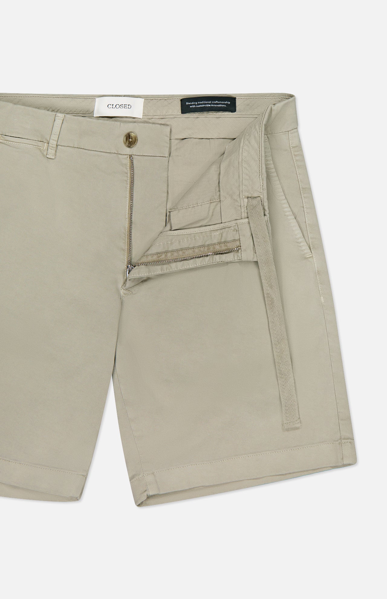 CLOSED Classic Chino Shorts in beige stretch cotton twill, featuring a zipper fly and button closure. Partially unzipped to show the inner waistband and pocket lining, shorts are laid flat on a white background.