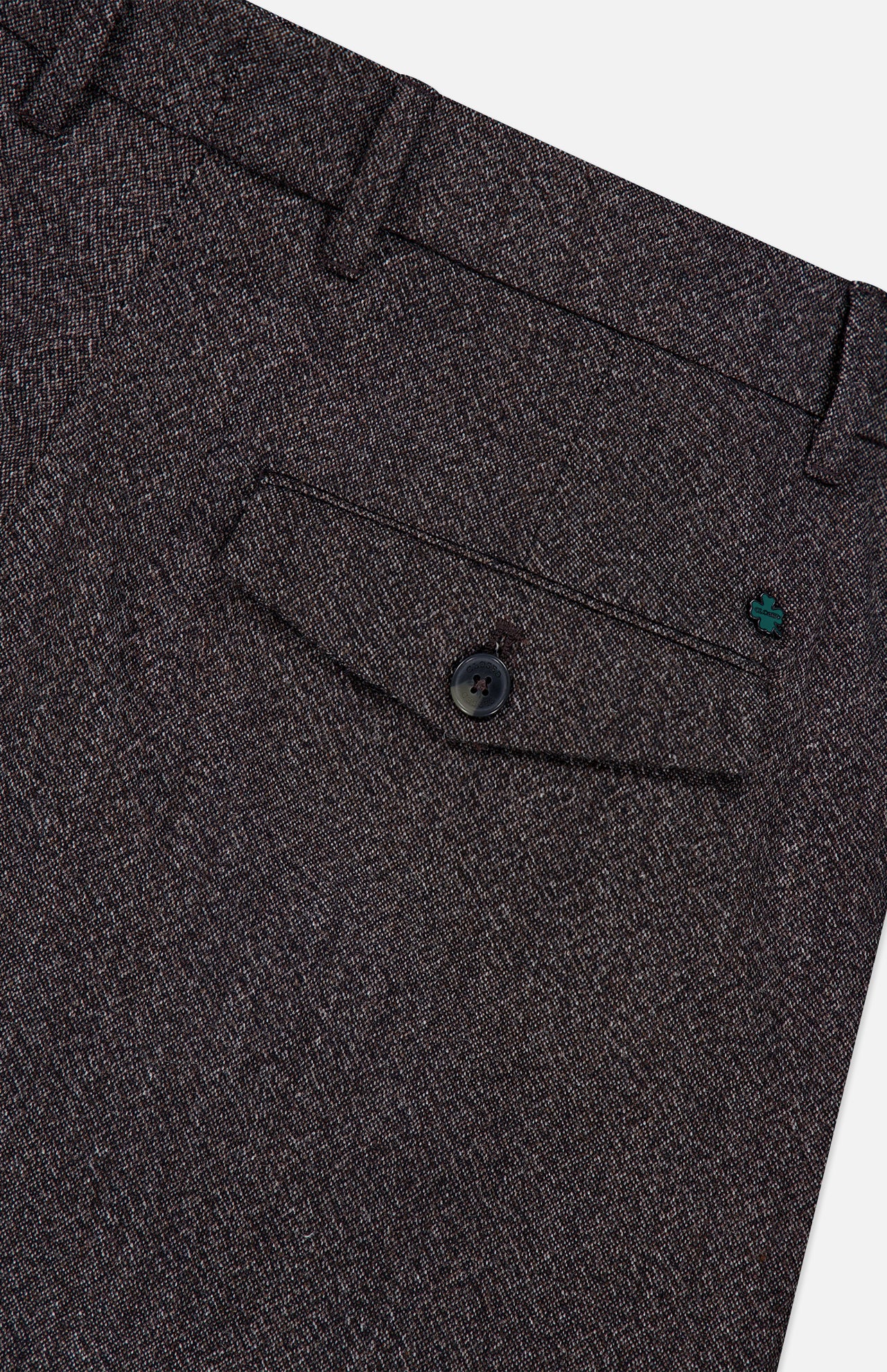 Close-up of the Fairport Relaxed Trouser Pant by CLOSED in dark brown, crafted from a textured wool-blend fabric, featuring a buttoned back flap pocket with a small green stitched detail above it.