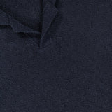 Close-up of the French Terry Johnny Collar Polo Shirt by CLOSED in dark navy textured fabric, featuring a Johnny collar and a white label displaying the brand name.