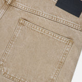 Close-up of the back pocket and waistband of the Shoreham Wide Pant in light brown beige denim with visible stitching and a black leather CLOSED brand patch on the waistband, highlighting the refined craftsmanship typical of wide fit jeans made in Italy.