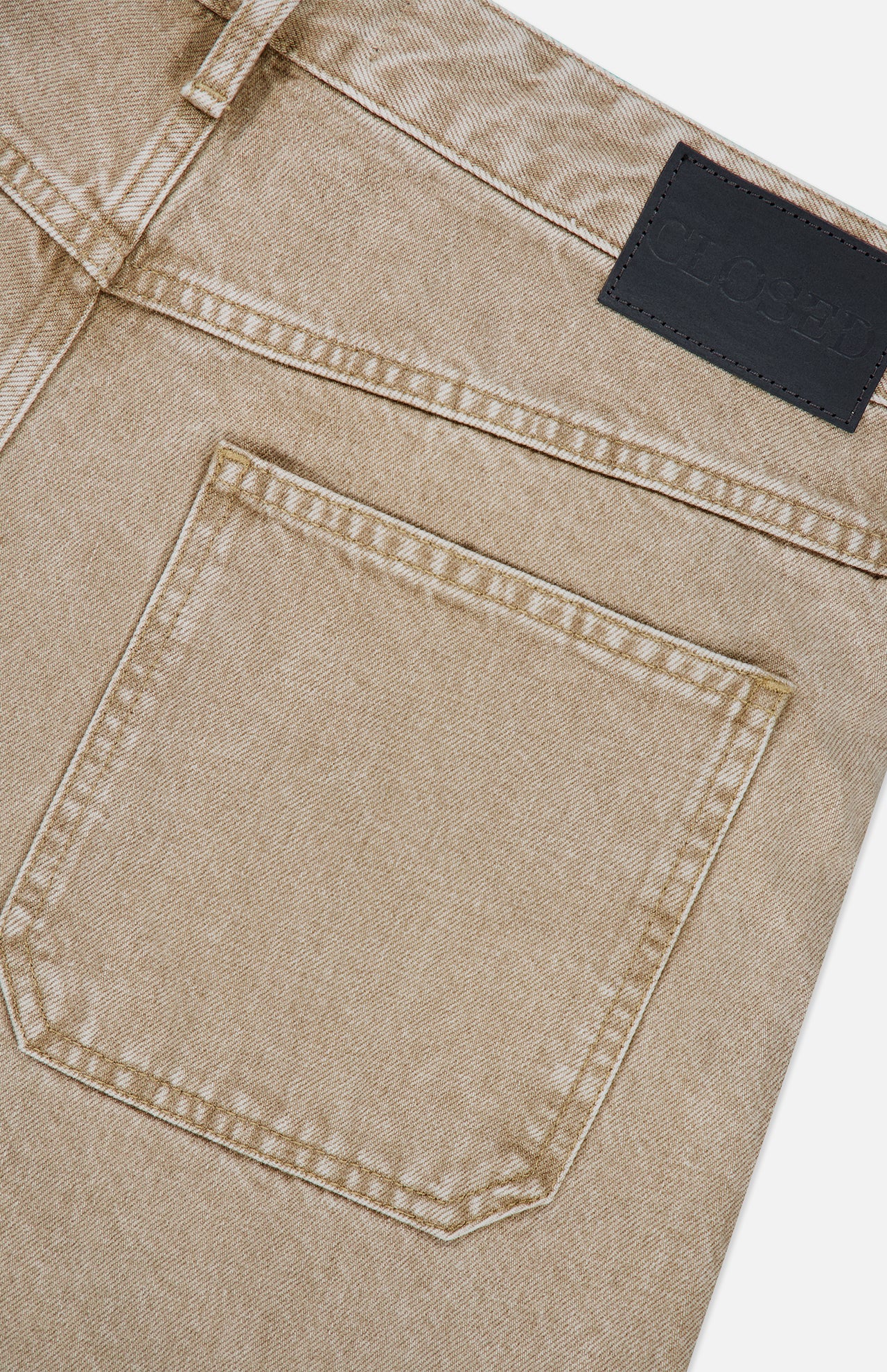 Close-up of the back pocket and waistband of the Shoreham Wide Pant in light brown beige denim with visible stitching and a black leather CLOSED brand patch on the waistband, highlighting the refined craftsmanship typical of wide fit jeans made in Italy.