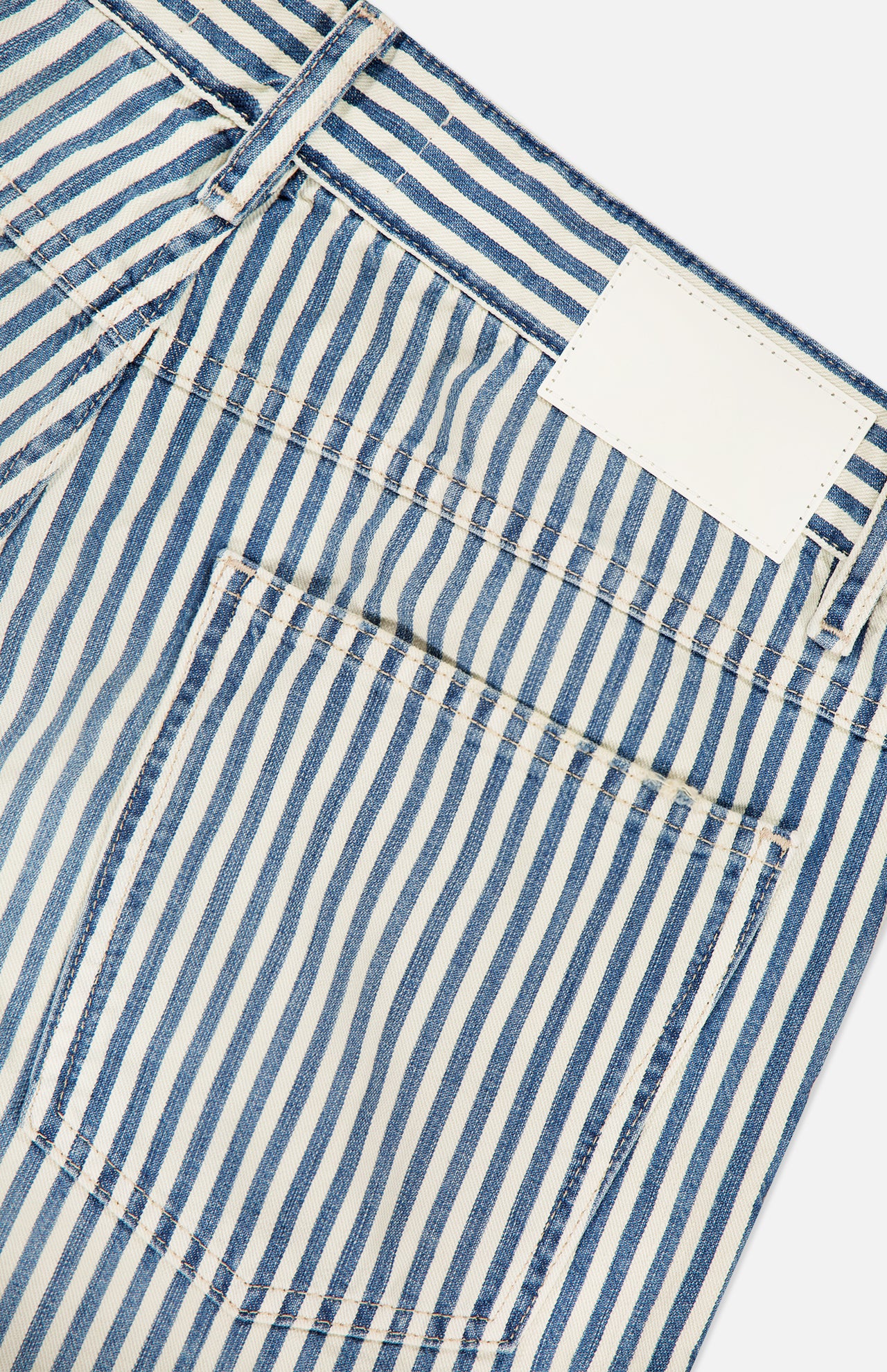Close-up of the back pocket and waistband of CLOSED Springdale Relaxed Stripe Pants in blue and white striped 100% cotton denim, featuring visible stitching and a blank white label on the waistband.