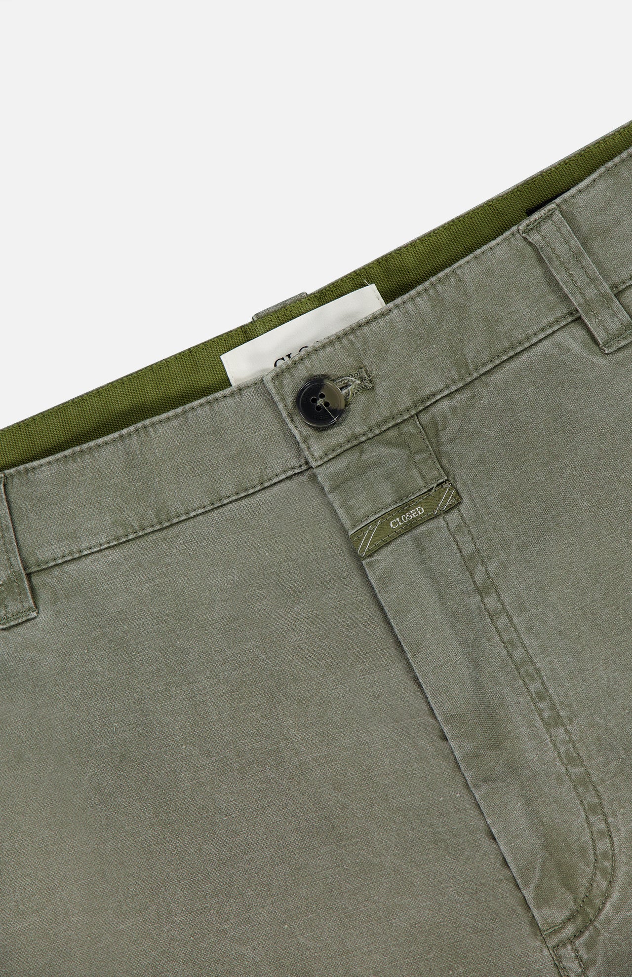 Close-up of the waistband and upper front of CLOSED's Toledo Tapered Trouser Pants in olive green cotton, featuring belt loops, button closure, visible stitching, and a partially visible white label.