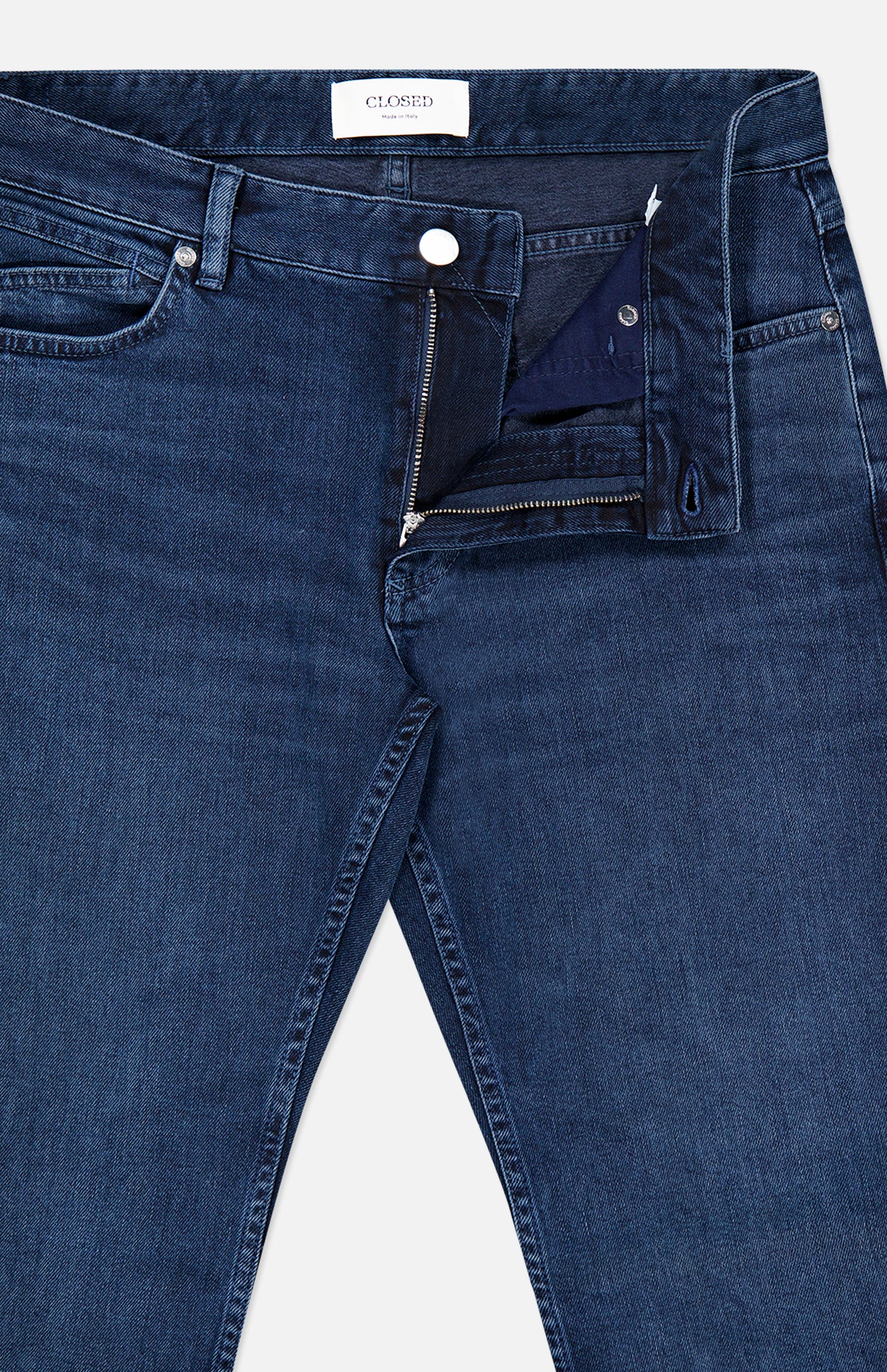 A pair of CLOSED Unity Slim Jeans crafted from dark blue denim with a partially unzipped fly and an unbuttoned waistband, laid flat on a white background.
