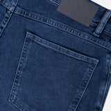 Close-up of the back pocket and waistband of the CLOSED Unity Slim Jean in dark blue denim, featuring a dark leather patch with embossed branding and visible stitching details.