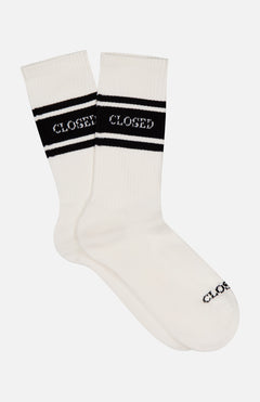 The CLOSED Striped Logo Sock is a white pair with two black stripes near the top, featuring the CLOSED logo in white on the stripes and in black on the toe for a classic look.