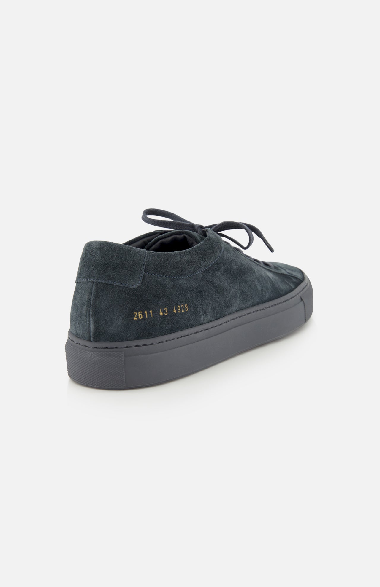 The COMMON PROJECTS Achilles Suede Premium Sneakers are luxury low-top navy suede sneakers featuring laces, a gray rubber sole, and gold numbers 2611 43 4298 on the heel, shown against a plain white background.