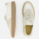 A pair of COMMON PROJECTS Bball Duo Leather and Suede Sneakers in white and beige, featuring gum soles. One off-white leather sneaker is displayed from the side, while the other is shown from above, highlighting the laces and a gold-stamped brand name on the insole. Set against a white background.