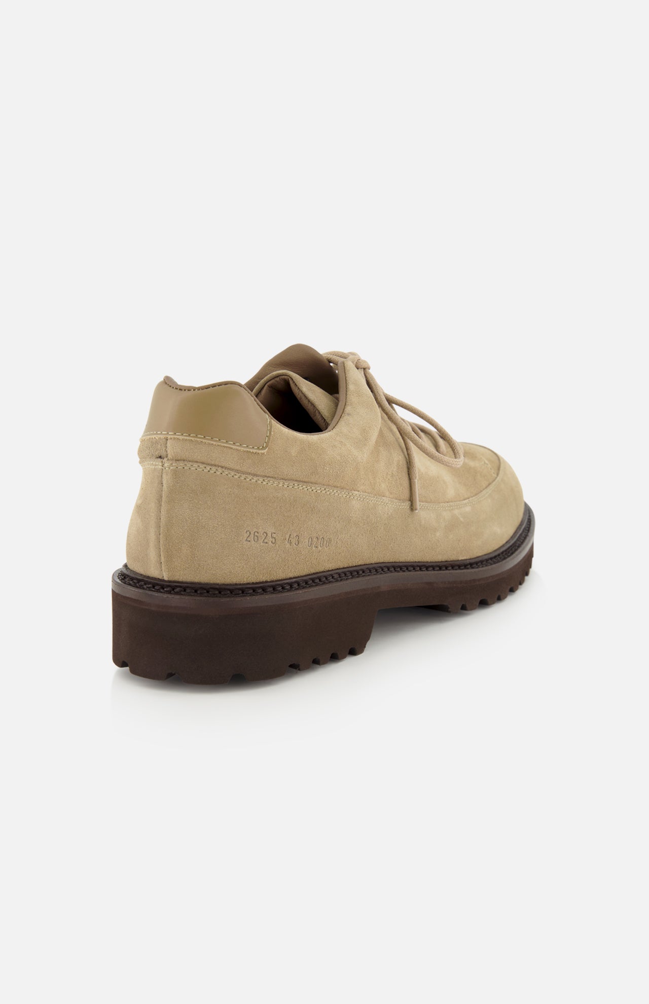 The COMMON PROJECTS Hiker Low Suede Piuma Boot in tan suede is displayed at a back angle, highlighting its lace-up design and thick, dark brown sole. Size and style numbers are stamped on the side near the heel.