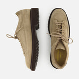 A pair of COMMON PROJECTS Hiker Low Suede Piuma Boots in beige suede, featuring chunky dark brown soles, is displayed from the side and top view against a white background.