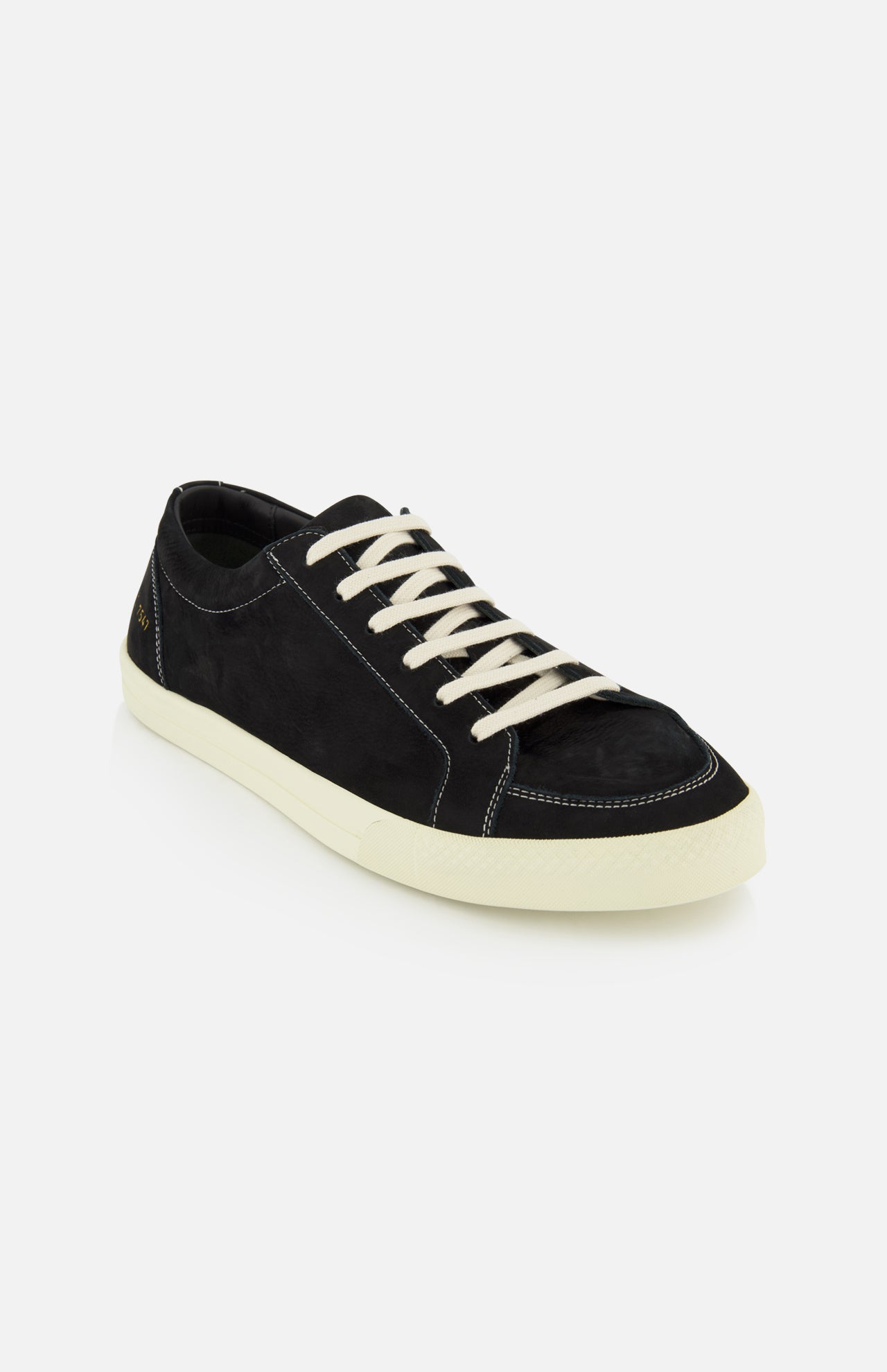 The COMMON PROJECTS Premium Skate In Nubuck Sneaker, a luxury black nubuck low-top with white laces and an off-white rubber sole, is displayed against a plain white background.