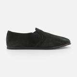 The COMMON PROJECTS Suede Slipper Shoe features a minimalist black suede design with a thin black sole, no visible laces or embellishments, and is shown in side profile against a white background.