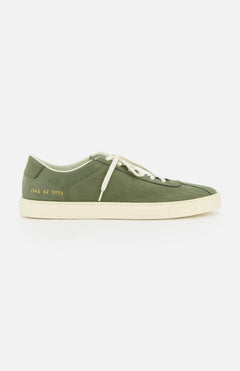 The COMMON PROJECTS Leather Tennis Sneaker is a luxury army green street shoe with white laces, a clean white sole, minimalist design, and a small gold serial number on the heel. Photographed against a plain white background.