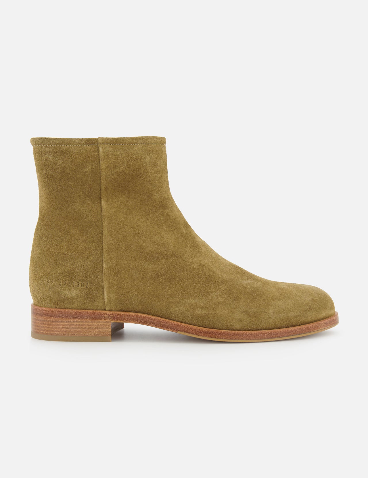 The COMMON PROJECTS Suede Zipper Boot is a tan suede ankle boot with a low wooden heel and minimalist design, shown in side profile against a white background—ideal for lovers of simple, elegant boots.