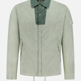The C.P. COMPANY 50 Fili Two-tone Overshirt is a light gray-green technical overshirt with a dark green collar and chest placket, zippered front pockets, a sleeve pocket, chest logo, relaxed fit, and drawstring hem for utilitarian style.