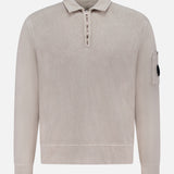 The Malfile Fleece Polo Collar Sweatshirt by C.P. COMPANY is a beige designer pullover with long sleeves, polo collar, half-zip front, and a patch pocket on the upper left sleeve finished with a signature black button detail.