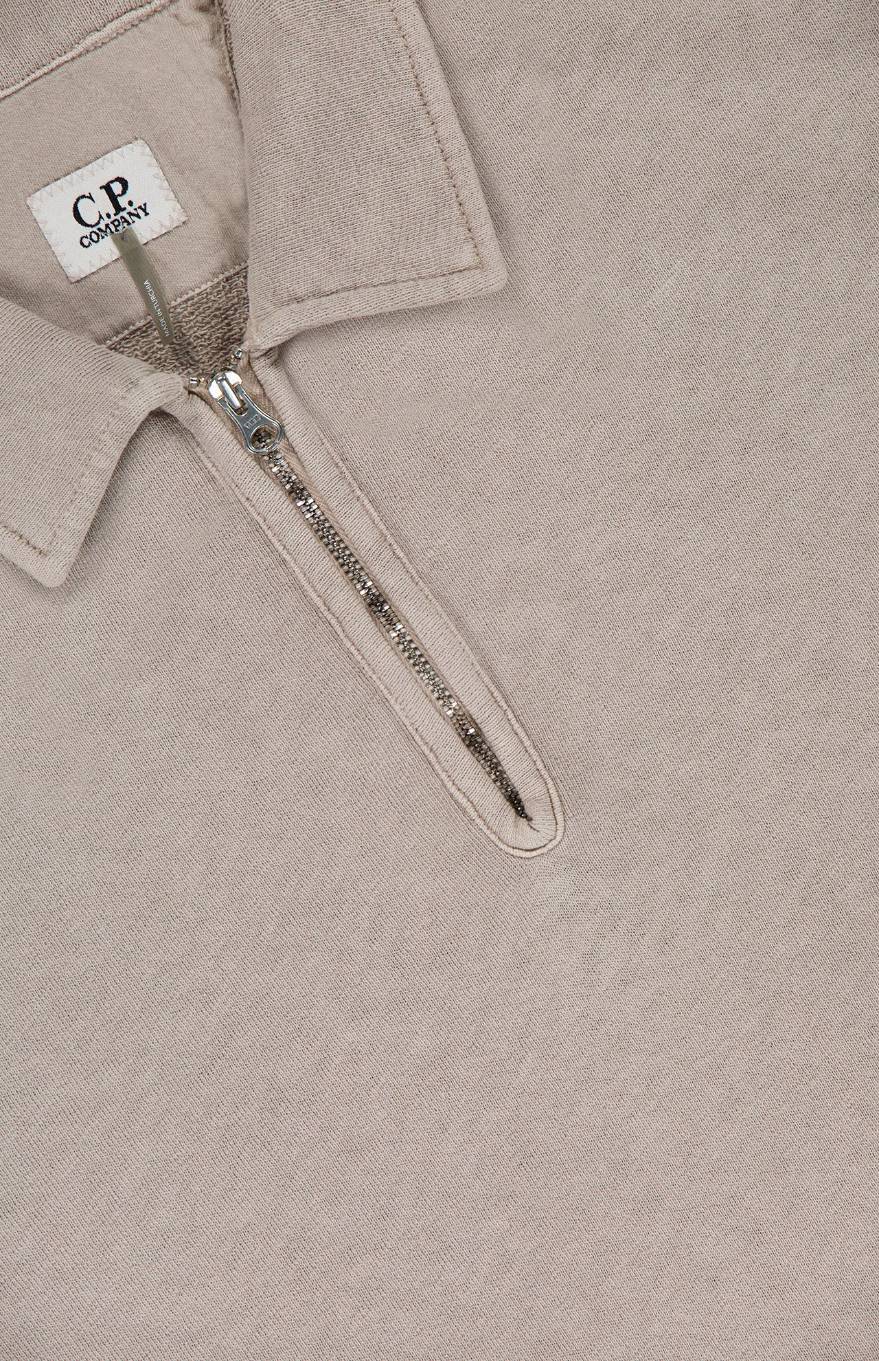 The Malfile Fleece Polo Collar Sweatshirt by C.P. COMPANY blends classic cotton polo style with designer sportswear, featuring a beige shade, visible half-zip closure, and an inner C.P. Company label.
