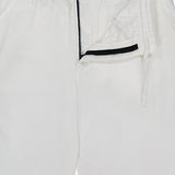 The C.P. COMPANY Micro-Reps Boxy Loose Pants in white feature a drawstring waistband, button closure, and open black zipper fly, crafted from high-density cotton and shown laid flat.