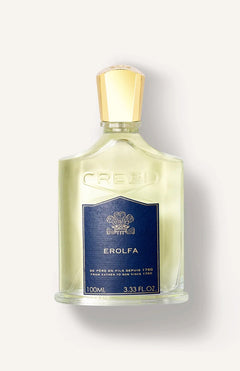 A clear glass bottle of CREED Erolfa 100ml, a fresh aromatic fragrance with Mediterranean notes, features a gold cap and a dark blue label showing the CREED brand, Erolfa name, and the 100ml (3.33 fl. oz) size.